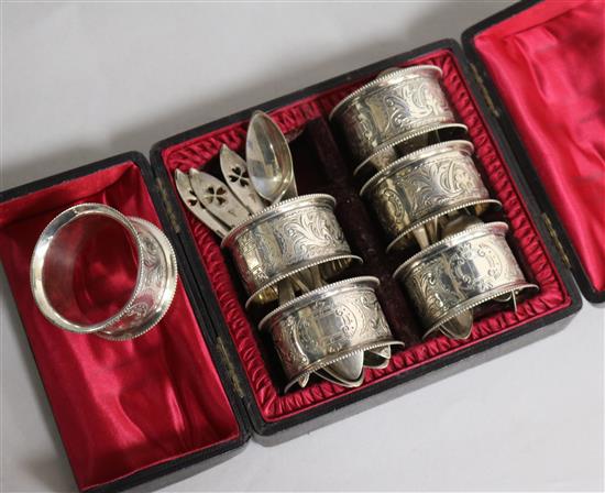 A cased set of six silver plated napkin rings and assorted small continental white metal flatware.